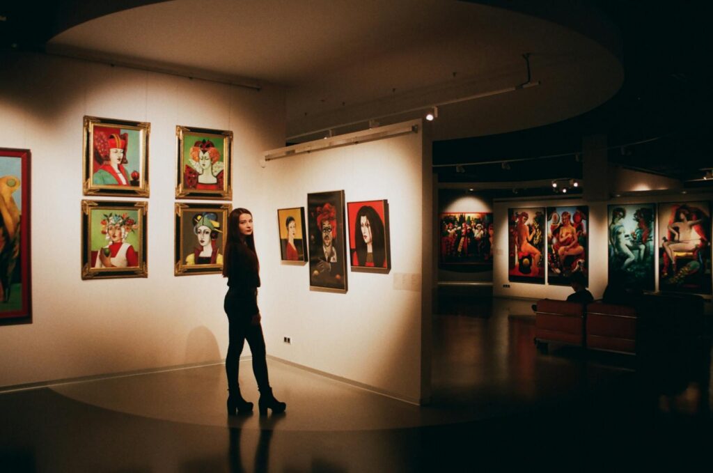 Woman Wearing Black Top Standing Near Paintings